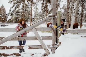 两个女学生在雪地里的牧场工作