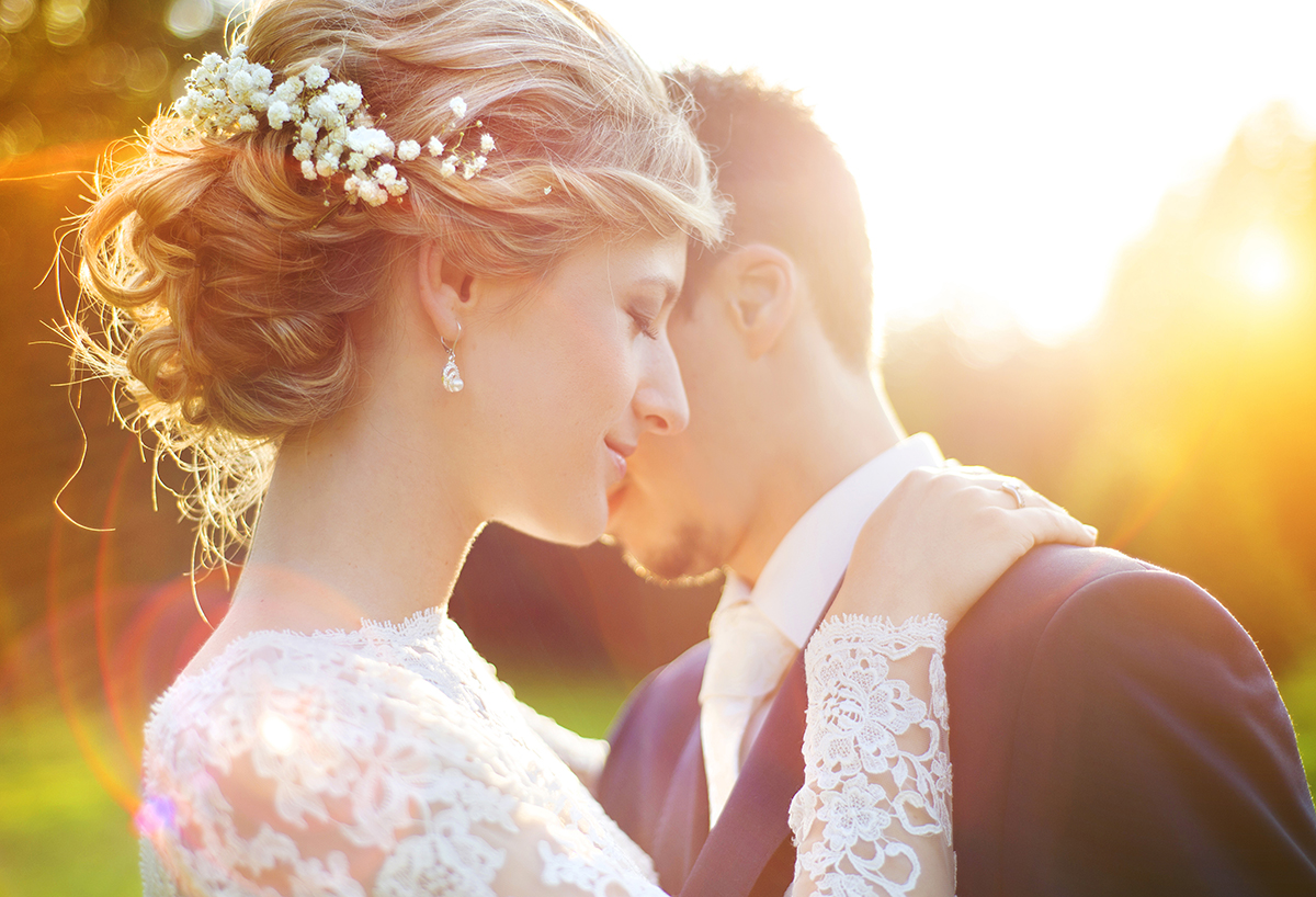 年轻的新婚夫妇在夏日草地上享受浪漫时刻的照片