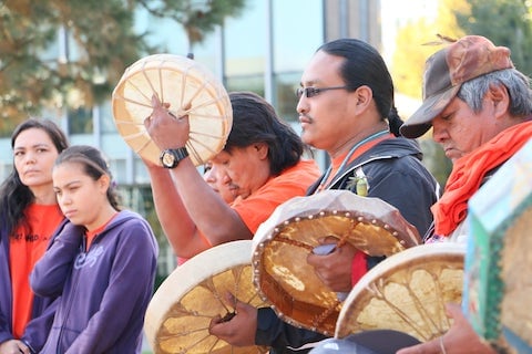 一名男子在土著和解活动中演奏仪式鼓