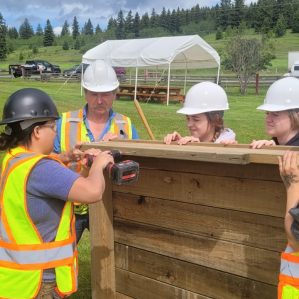 来自第一个职业女性探索项目的学生正在为108英里房屋遗产遗址的一个木工项目工作。